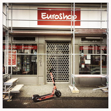 A scooter parked outside the now closed Euroshop discount store.  The Berlin district of Moabit is an artificial island completely surrounded by water that was once home to various industries and stau...