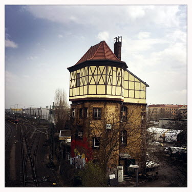 An old timber-framed railway building near a freight depot.  The Berlin district of Moabit is an artificial island completely surrounded by water that was once home to various industries and staunchly...