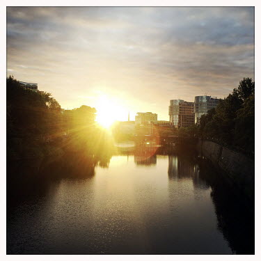 The sun sets behind the river Spree in Moabit.  The Berlin district of Moabit is an artificial island completely surrounded by water that was once home to various industries and staunchly working-clas...