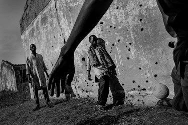 Boys play football outside former school building at Gwoza IDP camp. The town was the scene of heavy combat and many of the buildings are pockmarked from bullets and semi-derelict after sustaining she...