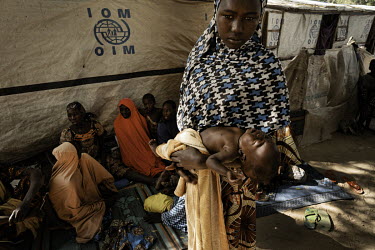 A woman, a recent arrival at an IDP camp in Bama, holds a baby. Many of the new arrivals described how they have fled from camp to camp and town to town, some from neighbouring Cameroon. Many of those...