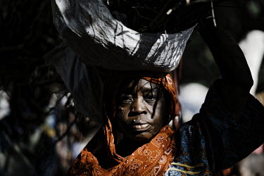 Falmata returns to Bama IDP camp after a threeÂ� kilometre walk carrying a load of fire wood gathered beyond the trench which surrounds Bama. Every trip she takes she risks being kidnapped or killed...