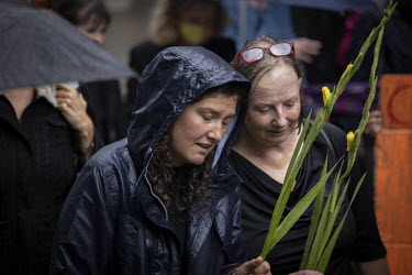 Two women holding flowers at the 'opening ceremony' of the 'August 2021 Rebellion', a funeral march with an 'earth coffin' to The Guildhall, home to the City of London Corporation. Extinction Rebellio...