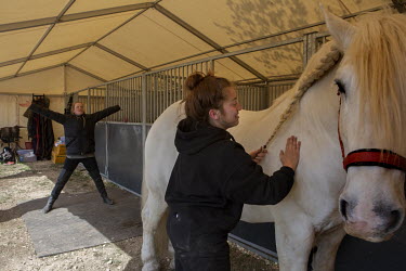 Groom Camille Smith prepares Tony the horse for the ring rehearsals while equestrienne Rebecca Musselwhite prepares herself with stretches.   Giffords Circus have been rehearsing for 'The Hooley', the...