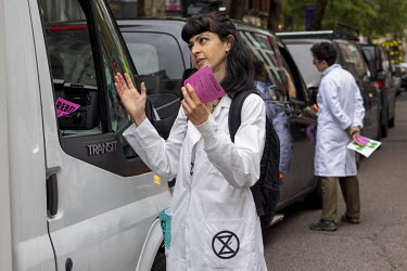An Extinction Rebellion activist talks to drivers during a march and occupation in London's West End.