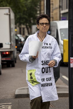 An Extinction Rebellion activist wearing a lab coat emblazoned with 'I am a Scientist' talks to drivers during a march and occupation in London's West End.