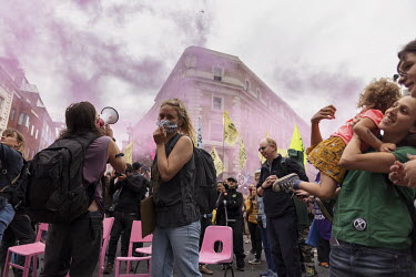 Smoke rises around Extinction Rebellion activists taking part in an occupation protest in London's West End.