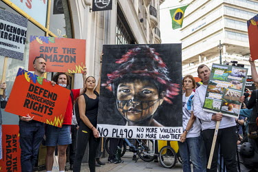 Activists protesting the planned Brazilian legislation, Bill PL490, holding a poster of an Indigenous child during the 'Amazon Rebellion' outside the Brazilian Embassy. The protest was joined by vario...