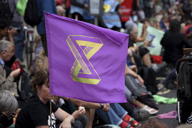 An Extinction Rebellion (XR) flag displayed during an XR 'Stop the Harm' march from Hyde Park to the Department for Business, Energy and Industrial Strategy.