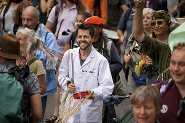 A man wearing a lab coat with the slogan 'I am a scientist' as Extinction Rebellion activists take part in the 'Stop the Harm' march from Hyde Park to the Department for Business, Energy and Industria...