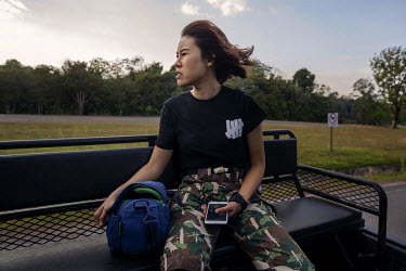 Chananya Kanchanasakha, a Park ranger and veterinarian, rides in the back of a truck to a report of an elephant sighting in Khao Yai National Park.