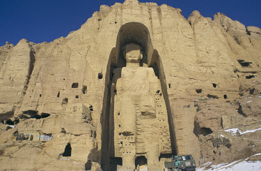 An army truck parked in front of the large, or 'Western' Buddha of Bamiyan (55 metres high, 6th-7th century CE) in Bamiyan in the snow. The Buddhas were destroyed by the Taliban in 2001.