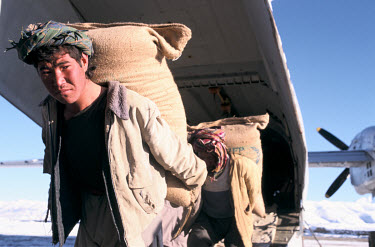 Young men unload a World Food Programme airlift. Shortly afterwards the Taliban bombed close to the airstrip as a warning for the plane to leave.