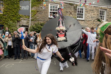 Padstow, Cornwall, England. Tourists watch participants in Padstow's annual festival on May 1st celebrating the approach of summer. Known as the 'Obby Oss' its origins are ancient and pagan. Today's p...