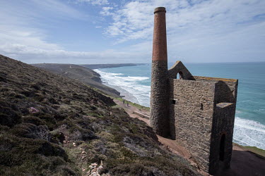 Walkers approach the ruins of a coastal tin mine at Saint Agnes Head. This was the Wheal Coates Engine House which brought men and tin up from mines which stretched out under the sea. The mines have b...