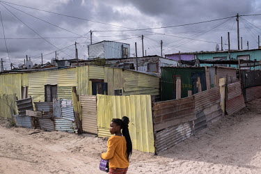 A girl walks past shacks in the township of Khayelitsha, in Cape Town. More than a quarter of a century after the end of apartheid, Cape Town remains highly segregated, and in townships like Khayelits...