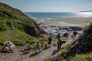 A family with their dogs goes to the beach on the Pembrokeshire coast.
