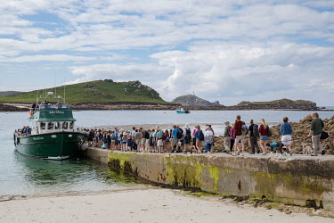 Tourists line up to board an inter island ferry on Tresco in the Scilly Isles. The Scillys, with their remote location off the southwestern tip of Cornwall attract more and more tourists from the UK w...