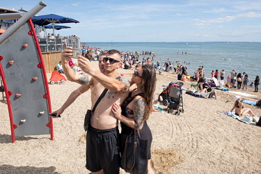 People take selfies at the beach at Southend-on-Sea, a popular destination for people from London and Essex.