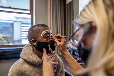 Ayabonga Tshofui, a student of the Cape Town College of Magic, has his face painted before a performance at the Artscape Theatre.