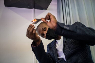 Anele Dyasi, 23, teacher and former student of the Cape Town College of Magic, burns a playing card while demonstrating a trick to a class of students. Dyasi, who comes from one of Cape Town's poorest...