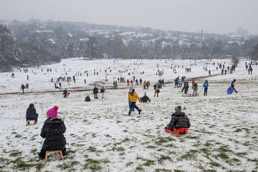 People sledging on London's Hampstead Heath in the snow during the Coronavirus pandemic. With foreign travel to winter sun and / or ski resorts not permitted, the Heath became extra busy under a light...