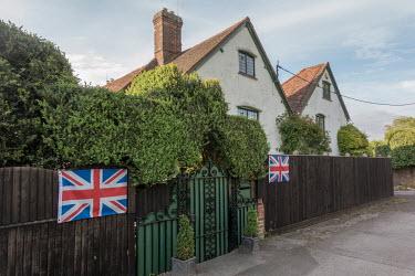 A house in the Buckinghamshire countryside with two British flags on the front fence.