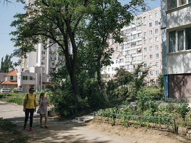 Two women walk through a residential area in Tiraspol.