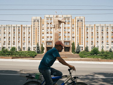 A man cycles past the Transnistrian Parliament in Tiraspol. Transnistria, officially part of Moldova, is an unrecognised breakaway state that unilaterally declared independence in 1991.