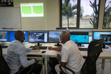 Staff members at AEGOS, a satellite monitoring agency that works in the Gabon Special Economic Zone, a controlled hub for the extraction of timber on a sustainable basis, monitor screens, looking for...