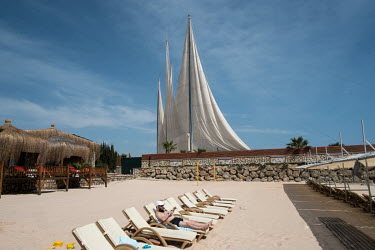 A man sunbathes on the beach in the male only area of the beach at the Adenya Hotel and Resort. Halal hotels have sex segregated swimming pools, beaches, and spa facilities.