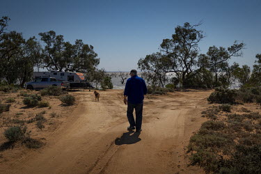 Phil Turner walks towards his caravan on the edge of Lake Pamamaroo where he has been isolating with his wife for the last 3 weeks. Phil, the owner of the Marree Hotel, has been stuck at the New South...