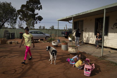 A family of 10 in Wilcannia who are currently isolating spend time outside their small house.