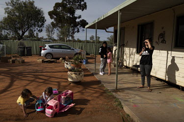 A family of 10 in Wilcannia who are currently isolating spend time outside their small house.