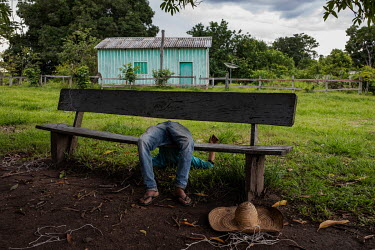 A drunken resident is slumped on a bench in the quilombola (founded by escaped slaves) community of Pedras Negras in Rondonia.