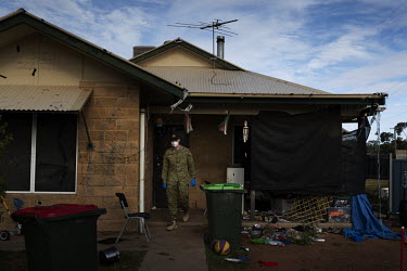 Australian Army soldier Johnson Humphreys knocks on the front door of a house where people are currently isolating.