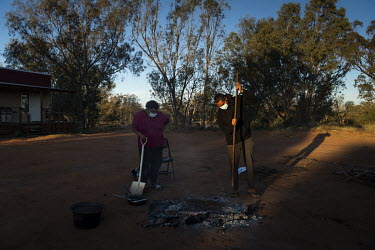 Raylene Hunter and Anthony Dutton prepare a fire pit outside the Warrawong quarantine facility where they are currently isolating to cook kangaroo tails, a popular food for Barkindji people. The meat...