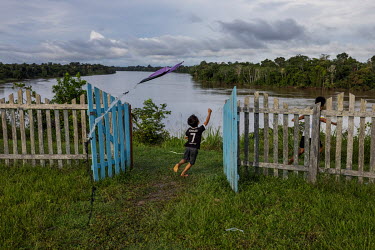 A boy flies a kite in the yard in front of the Brotherhood of the Holy Cross Church, a religious movement founded by Jose Francisco da Cruz in the 1970s, in the village of Sao Pedro do Norte on the ba...