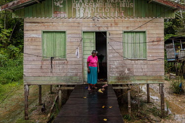 Maria Pereira da Gama, a riverside dweller who lived with the American Christian Baptist evangelical missionary Andrew Tonkin in the Sao Rafael community, stands in front of a community hall on the ba...