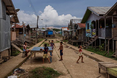 Children play table tennis on a street in a village in the Vale do Javari indigenous territory.