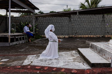 A woman, a member of the Brotherhood of the Holy Cross, a religious movement founded by Jose Francisco da Cruz in the 1970s, kneels in front of the church in a village in Vale do Javari indigenous ter...