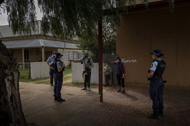 New South Wales police officers approach Lasonya Dutton, 31, Glenn Wilson, 35, and their 8 year old son as they walk back from the shops, informing them that they are under arrest for breaching covid...