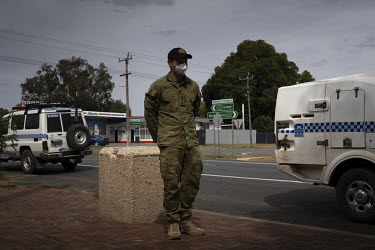 A solider watches the attempted arrest of Lasonya Dutton, 31, Glenn Wilson, 35 as they walk back from the shops, from a distance. Australia has deployed hundreds of soldiers throughout NSW to help enf...