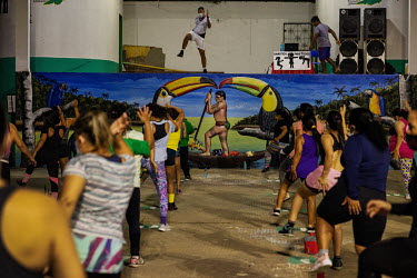 Residents take part in a gymnastics class in the village of Atalia do Norte on the banks of the Javari River in the Vale do Javari indigenous territory. A wall painting depicts toucan birds and an ind...