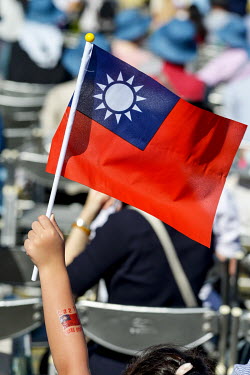A girl holds aloft an Republic of China (ROC) flag during National Day Parade for Year 110 (2021) of the ROC calendar (which began in 1911 after the end of the Qing Dynasty).