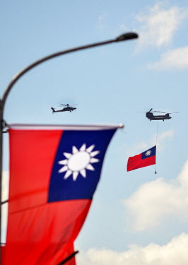 A Chinook helicopter towing a huge Republic of China (ROC) flag across downtown Taipei during National Day Parade for Year 110 (2021) of the ROC calendar (which began in 1911 after the end of the Qing...