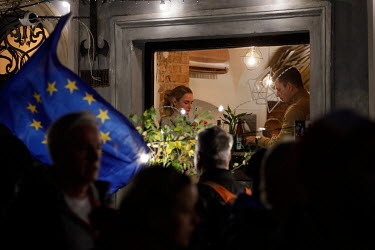 Diners are seen through the window of a restaurant as people gather for a rally in support of European Union ( EU ) membership in central Warsaw. The rally was organised after a recent ruling by the c...