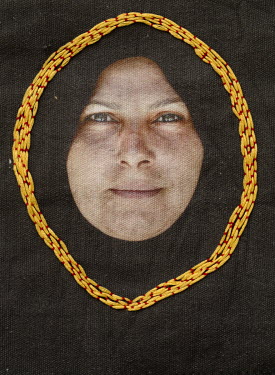 A photograph printed onto cotton and embroidered by the photographer.  Portrait of Um Mohammed, a hospital cleaner.