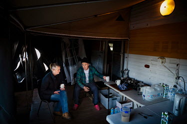 Kelvin and Kerry Pope drink tea near their caravan that has been covered in black plastic to protect it from asbestos dust in the air due to the bushfires.  Kelvin and Kerry Pope live 5km form Cobarg...