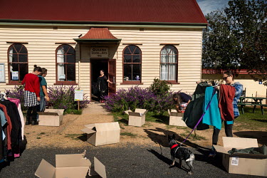 Locals from Quaama community who have been affected by the bushfires inspect donated clothing. Veronica Abbott (pictured in the door of the building, centre) runs the Quaama Bushfire Relief centre in...